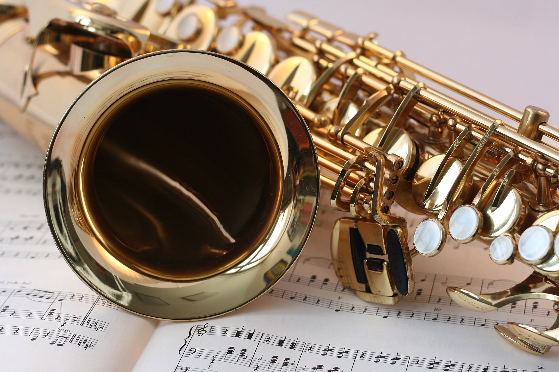 Detalhe de saxofone dourado sobre partitura